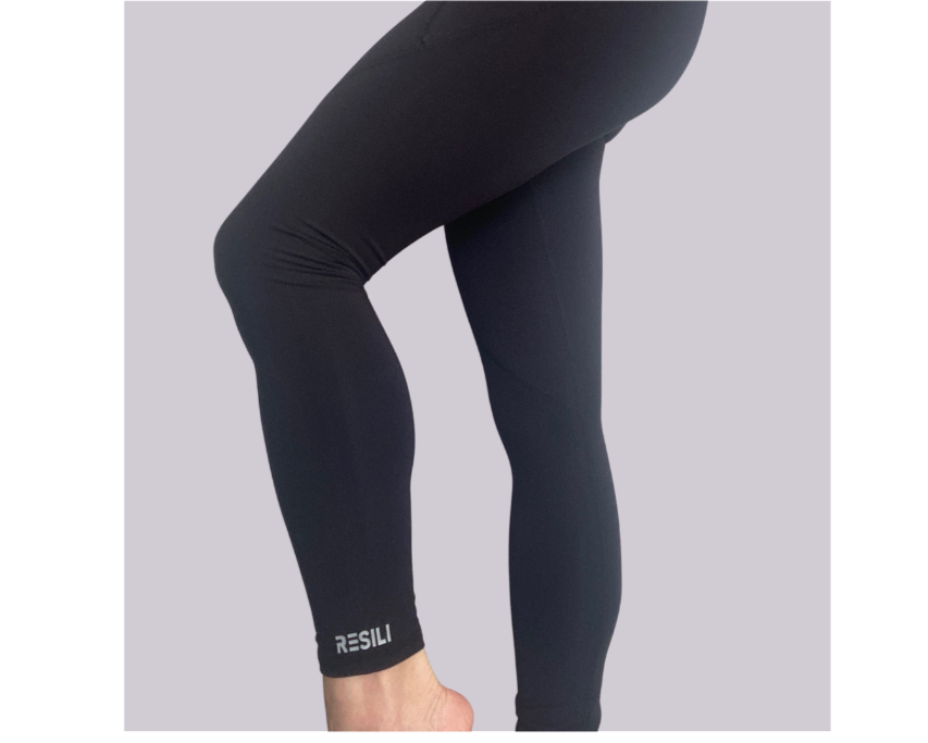 Black leggings with 'RESILI' branding on a light gray background