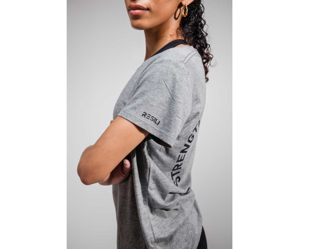 Person wearing a gray t-shirt with text on a plain background