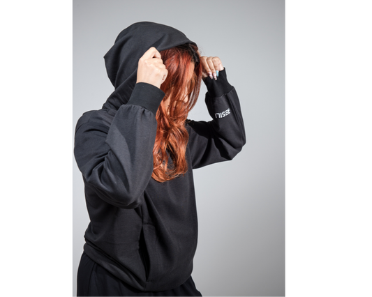 Person wearing a black hoodie with a plain background