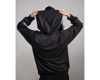 Person wearing a black hoodie with a brand logo on a gray background