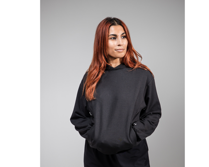 Person wearing a black hoodie on a gray background